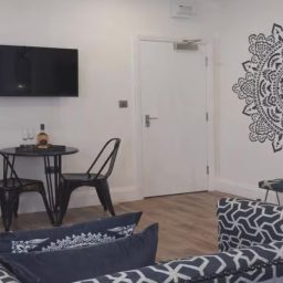 Modern living space with a TV, dining table, and decorative wall art.
