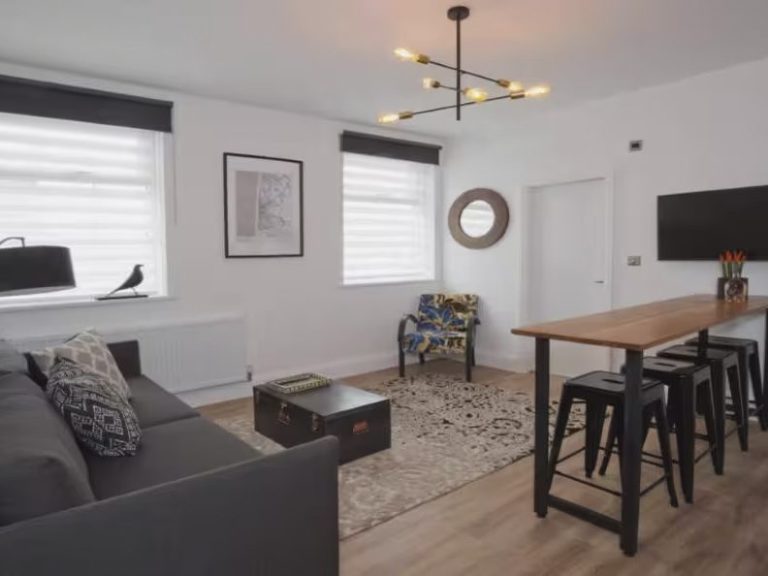 Modern living room featuring a sofa, dining table, TV, and stylish decor.