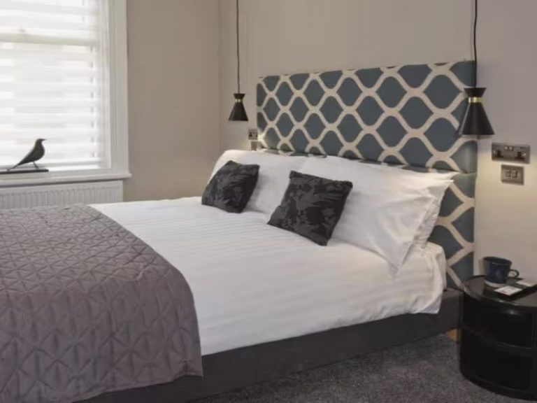 Stylish bedroom with a blue patterned headboard and elegant bedding.
